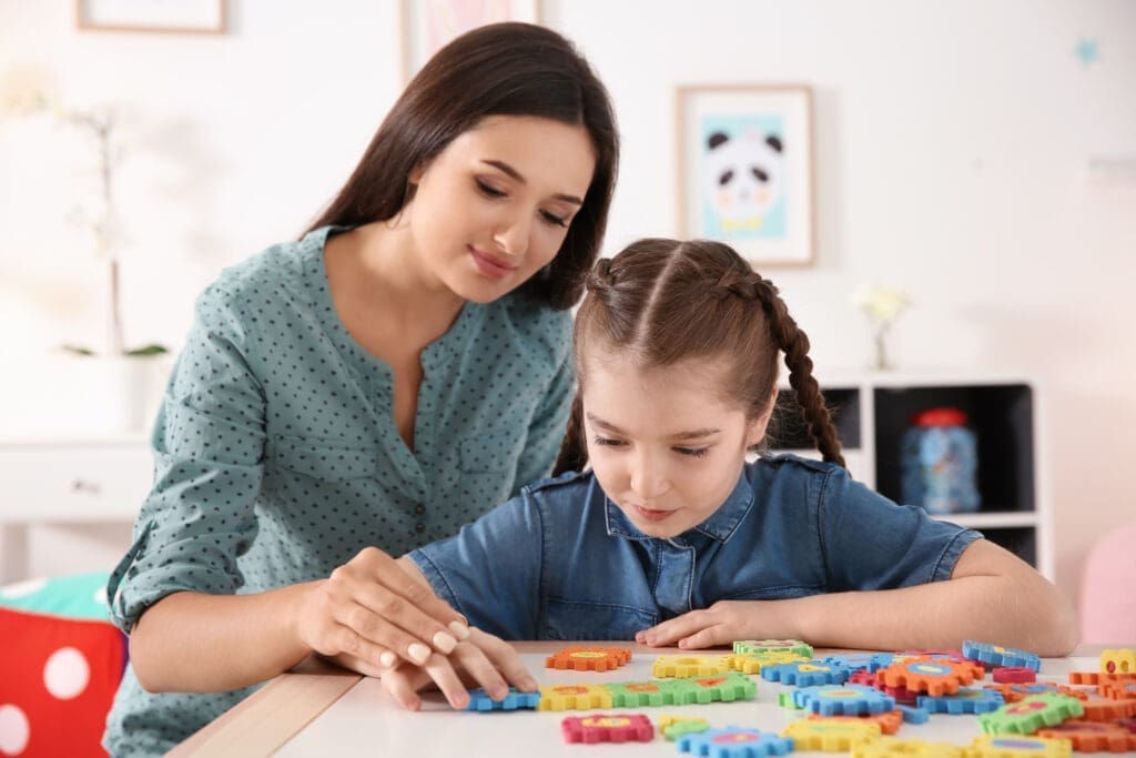 Mother and daughter doing play therapy for autistic child at home