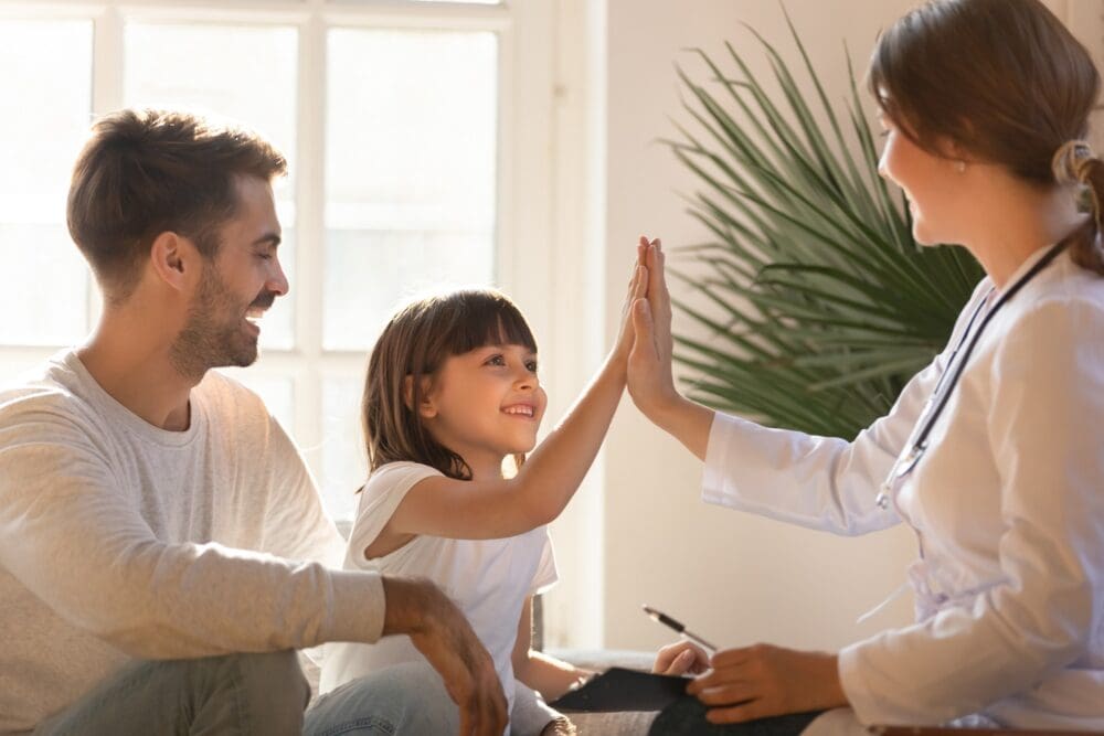 Woman Giving High Five to Child During Mental Health Counseling Session