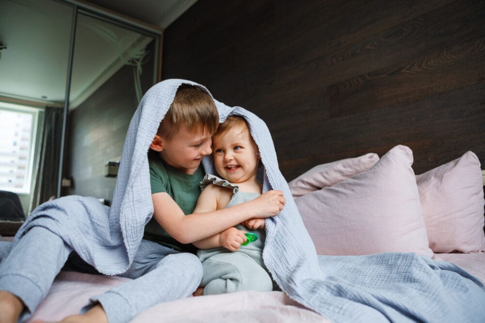 The little sister plays with her older brother at home